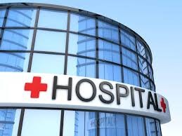 Hospital Management System - modern curved glass building facade with a prominent HOSPITAL sign and red cross
