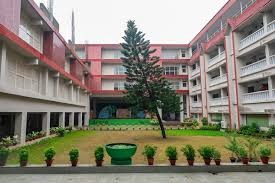School Management System - school campus building courtyard with a central tree and potted plants